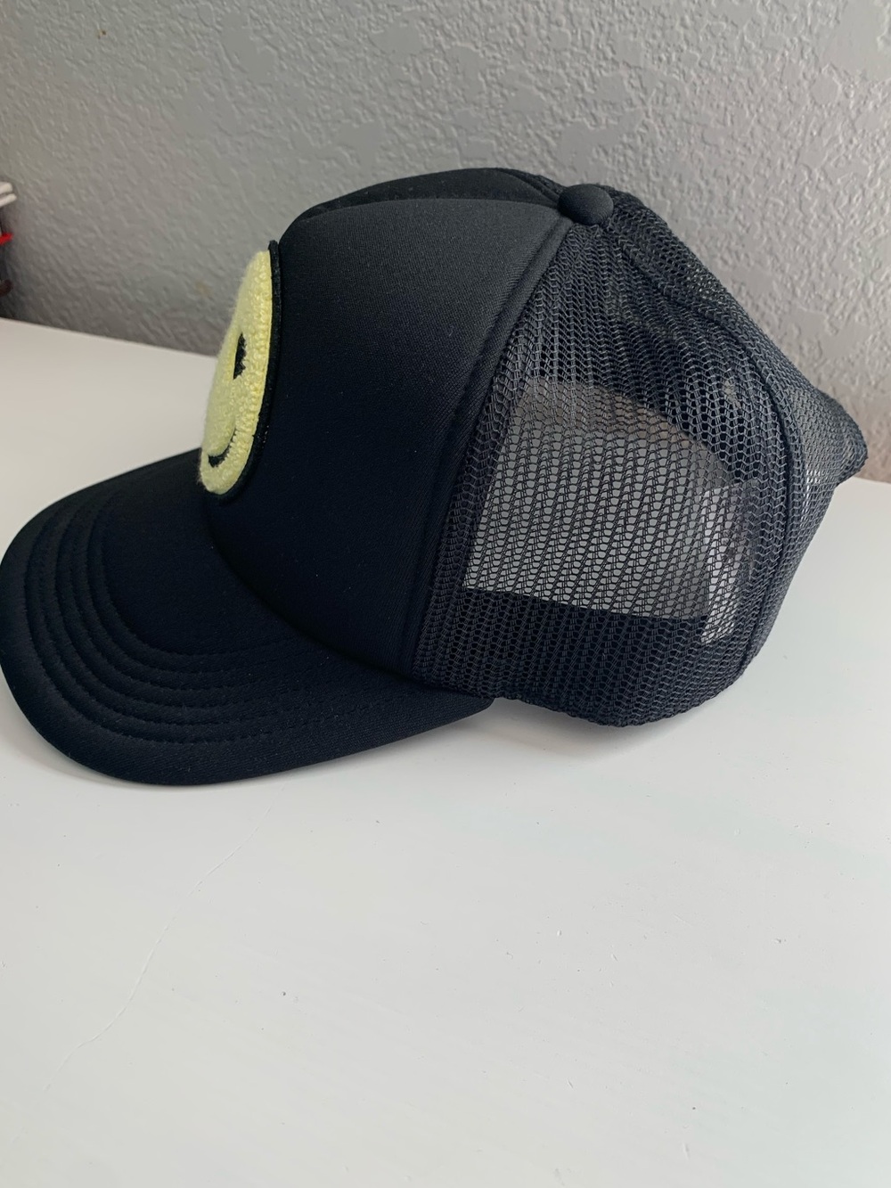 Black Trucker Hat with Yellow Fuzzy Smiley Face Patch with Heart-Eyes - Picture 3 of 6